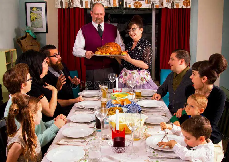 large family having and enjoying thanksgiving dinner roasted turkey menu