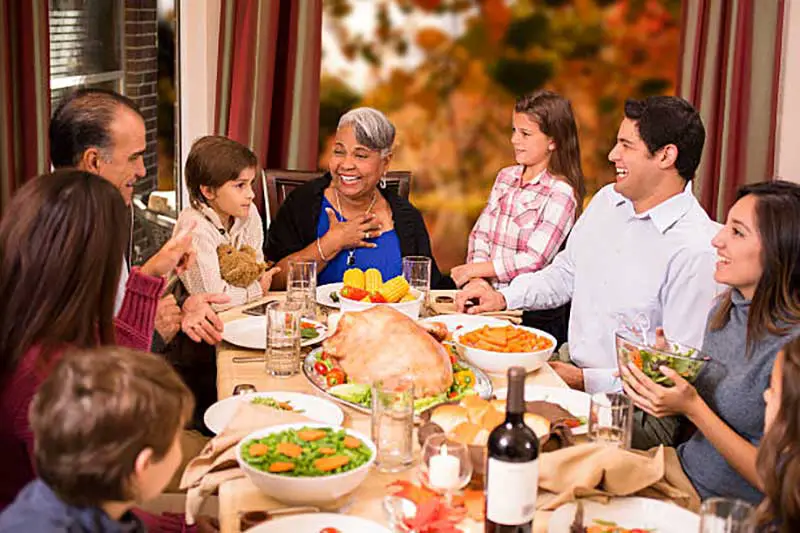 large family having and enjoying thanksgiving dinner
